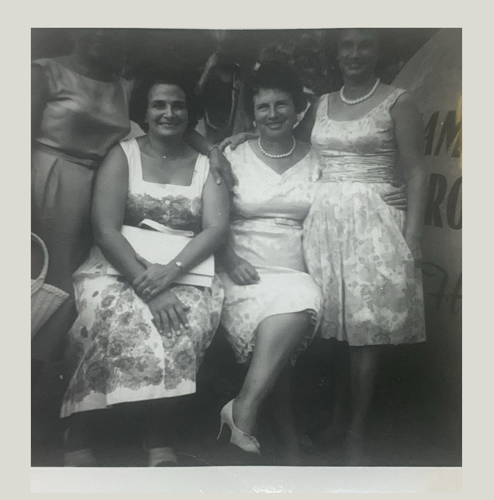 Questa fotografia inviata da una conflentese emigrata negli Stati Uniti d’America a Conflenti, paese calabrese in provincia di Catanzaro, ritrae tre donne, due sedute e una in piedi, tutte vestite in abito bianco. Si tratta di una foto di saluti inviata alla comunità.