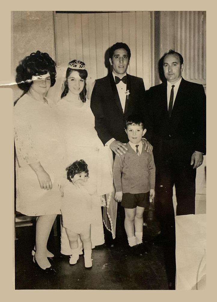 La foto ritrae una famiglia conflentese emigrata Melbourne in Australia durante un matrimonio e inviata a Conflenti, paese calabrese in provincia di Catanzaro. Gli sposi sono al centro ripresi in abiti nuziali. Lo sposo regge le sue mani sulle spalle del bambino con alla sua destra Guglielmo, Maria è in posa accanto la sposa.